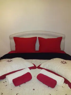 a bed with red and white pillows on it at Апартамент Стела in Sofia