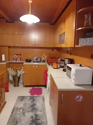 a kitchen with wooden cabinets and a white microwave at Апартамент Стела in Sofia