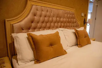 a bed with white pillows and a large headboard at Luxury Apartment Rich 2 in Velingrad