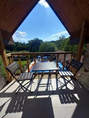 a picnic table and two chairs on a deck at Парк - Хотел Макензен in Melnik