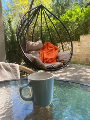 a coffee mug sitting on a table next to a swing at Terra complex -D6 - Balkan private apartment-Spa Sking Golf and Relax in Razlog