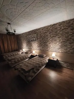 a room with two beds and a brick wall at Familia Apartments in Samokov
