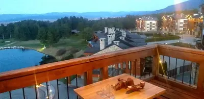 a balcony with a table and a view of a city at ALL VIEW in Golf Resort in Razlog
