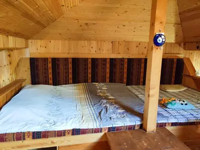 a bed inside of a wooden cabin at Терасите - Къща 1 in Ribarica