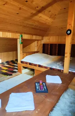 a room with a bed in a wooden cabin at Терасите - Къща 1 in Ribarica
