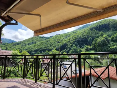 a balcony with a view of a mountain at Терасите - Къща 1 in Ribarica
