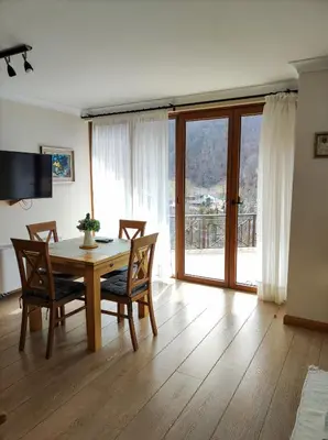 a dining room with a table and chairs and a window at Терасите - Къща 3 in Ribarica