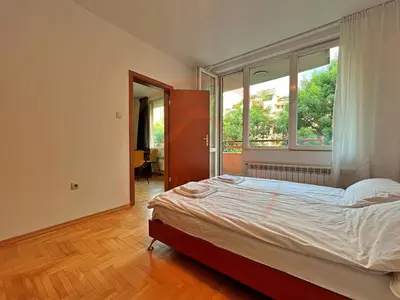 a bedroom with a bed and a large window at Tranquil Retreat in the Heart of Sofia: 2BR in Sofia