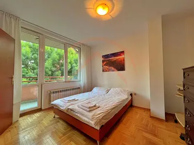 a bedroom with a bed and a large window at Tranquil Retreat in the Heart of Sofia: 2BR in Sofia