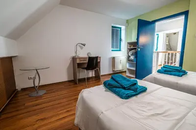 a room with two beds and a desk and a table at On the top! in Sofia
