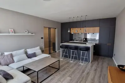 a living room with a couch and a kitchen at Mila's Cozy 1 Bedroom Apartment in Sofia
