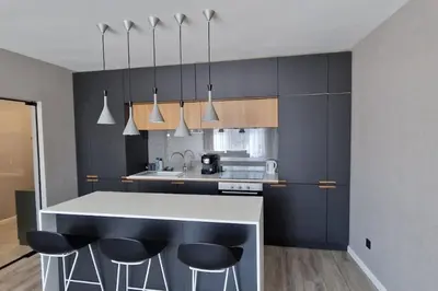 a kitchen with black cabinets and a counter with bar stools at Mila's Cozy 1 Bedroom Apartment in Sofia