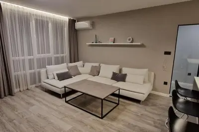 a living room with a white couch and a table at Mila's Cozy 1 Bedroom Apartment in Sofia