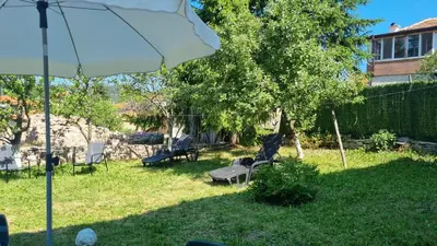 a yard with a statue of a bird sitting on a bench at Къща ВИРА in Yasă-Koriya