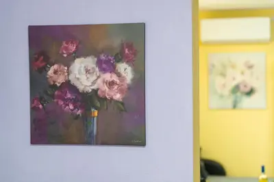 a painting of a vase of flowers on a wall at Sweet Home 1 in Sandanski
