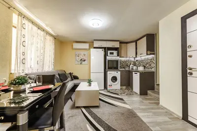 a kitchen and living room with a table and chairs at Sweet Home 1 in Sandanski