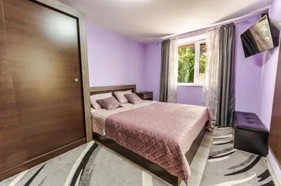 a purple bedroom with a bed and a sliding door at Sweet Home 1 in Sandanski