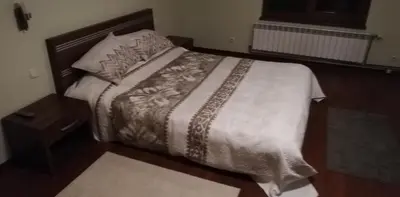 a bedroom with a large bed with a wooden headboard at Classic Hotel in Sofia