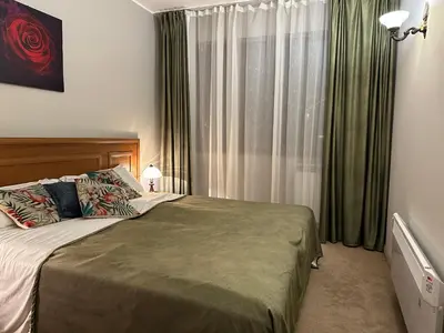 a bedroom with a bed and a window with curtains at Anna Apartment near Gondola in Bansko