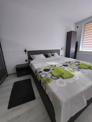 a bedroom with a large bed with green napkins on it at Апартамент Слави in Blagoevgrad
