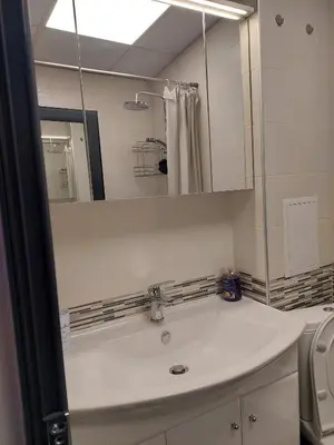 a white bathroom with a sink and a mirror at Апартамент Слави in Blagoevgrad