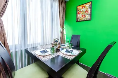 a green dining room with a black table and chairs at The Green Apartment 2BR - free parking in Sofia