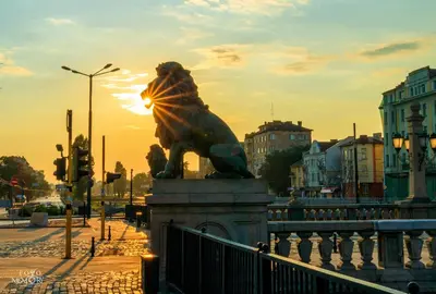 a statue of a lion on a bridge at sunset at The Green Apartment 2BR - free parking in Sofia