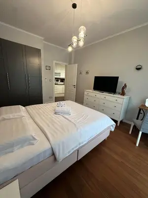 a bedroom with a large white bed and a television at Sofo house in Sofia