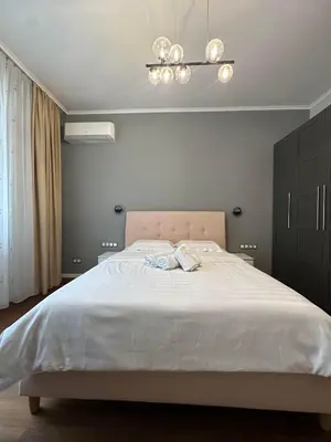 a bedroom with a large white bed with a chandelier at Sofo house in Sofia