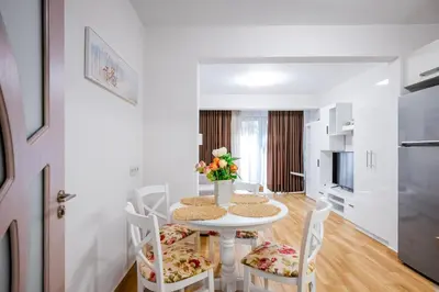 a white dining room with a table and chairs at 1BD Elegance on Vasil Levski Boulevard by Flat Mаnager in Sofia