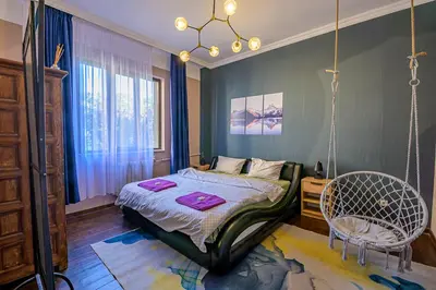 a bedroom with a bed and a chair in it at Top Center Relax, Vitoshka Str & NDК, FREE Parking in Sofia