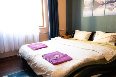 a bed with two purple towels on top of it at Top Center Relax, Vitoshka Str & NDК, FREE Parking in Sofia