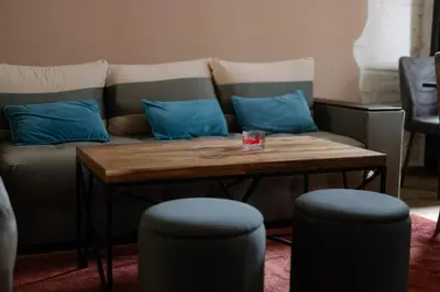 a couch with blue pillows and a wooden table at Top Center Relax, Vitoshka Str & NDК, FREE Parking in Sofia