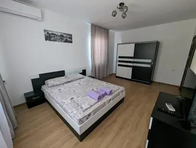 a bedroom with a bed and a flat screen tv at Апартамент Габи in Karlovo