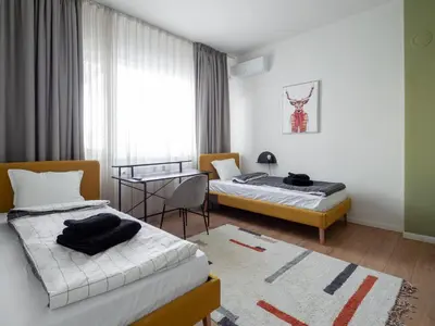 a room with two beds and a table and a window at Central Apartment Parking Two Bedrooms Sky Terrace in Sofia