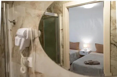 a mirror in a room with a bed and a shower at Къща за гости ЕМА in Vetren Dol