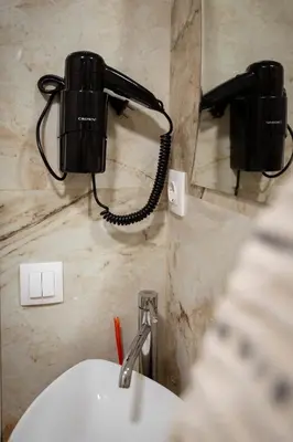 a bathroom with a sink and a phone on the wall at Къща за гости ЕМА in Vetren Dol