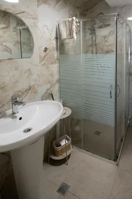 a bathroom with a sink and a glass shower at Къща за гости ЕМА in Vetren Dol