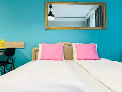 a bedroom with a bed with pink pillows and a mirror at Barbie Studio in Sofia