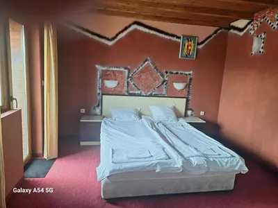 a bed in a room with a red wall at Victori SPA in Dobrinishte