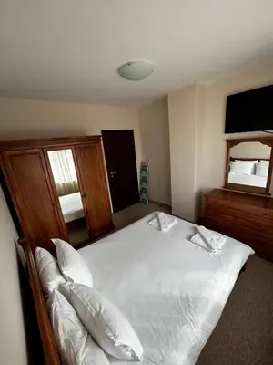 a bedroom with a large white bed and a mirror at Bansko Royal Towers Private Apartment V&K in Bansko