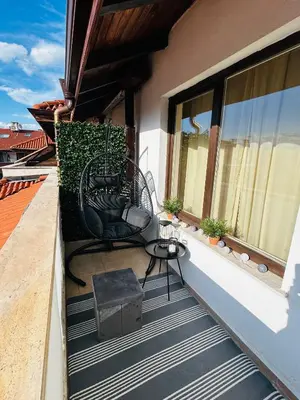 a balcony with two chairs and a table on a building at Bansko Royal Towers Private Apartment V&K in Bansko