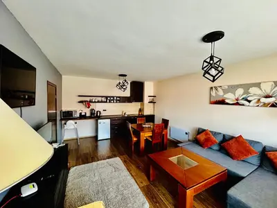 a living room with a blue couch and a kitchen at Bansko Royal Towers Private Apartment V&K in Bansko