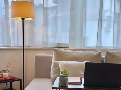 a laptop computer sitting on a table next to a couch at Sunny & Cozy Apartment for 4 Guests & Free Parking in Plovdiv