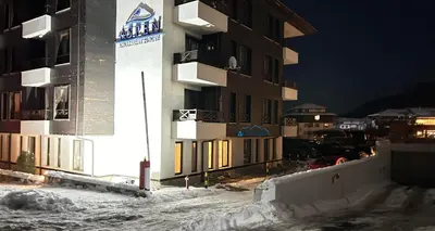 a building in the snow at night at ALTITUDE MOUNTAIN APARTMENTS ASPEN at GONDOLA BANSKO in Bansko
