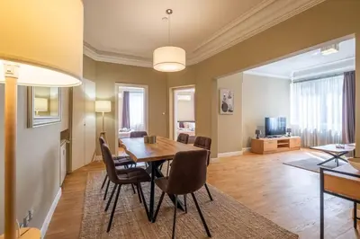 a dining room and living room with a table and chairs at Stunning Luxury 3 Bedroom Apt in the Heart of Town in Sofia