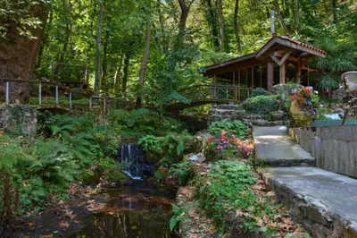 a garden with a pond and a cabin at Hotel Saint Nedelya in Kolarovo