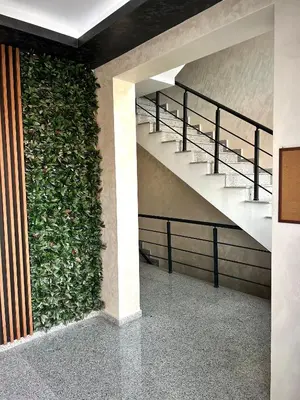 a green wall with stairs in a building at Ultra Lux Apartment Free Underground Secure Parking in Pazardzhik