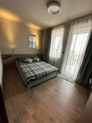 a bedroom with a bed and two large windows at Art apartment Pamporovo Grand Monastery in Pamporovo