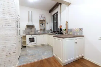 a kitchen with white cabinets and a white brick wall at Top Center Relax, NDK & Vitoshka str, FREE Secured parking in Sofia